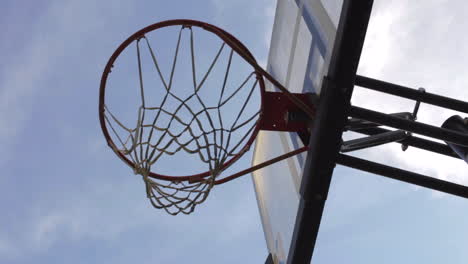 Schießen-Sie-Einen-Ball-In-Den-Basketballkorb-Vor-Blauem-Himmel