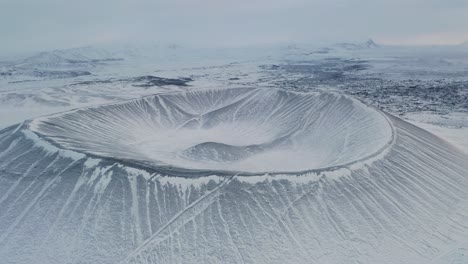 Sobrevuelo-Aéreo-Majestuoso-Volcán-De-Anillo-De-Toba-Hverfjall-Cubierto-De-Nieve-Y-Hielo-En-Islandia