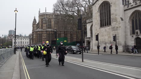 A-unit-of-Metropolitan-Territorial-Support-Group-riot-police-wearing-face-masks-march-forward-and-come-to-a-halt-near-Westminster-Abbey