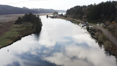 drone-flight-over-tranquil-Siuslaw-River-in-Florence,-Oregon,-USA-at-daytime