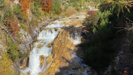 Amazing-colorful-landscape-with-waterfall-on-the-Karwendelsteg-trail-in-the-near-of-Scharnitz-in-Austria-with-deciduous-trees,-tilt-shot-close-up