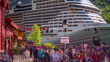 MSC-Meraviglia-Cruise-Ship-Docked-At-The-Harbour-In-Flam,-Norway-With-Crowd-Of-People-Walking-In-Foreground
