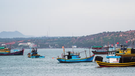 Colorful-vibrant-boats-of-fishermen-moored-near-coastline-of-Vietnam