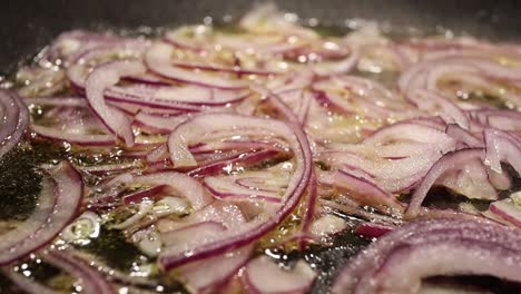 frying-the-fresh-red-onions-with-hot-oil-in-a-steel-pan---close-up-footage