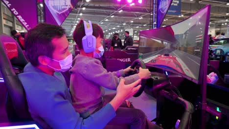 Father-and-son-play-themed-racing-videogames-during-the-International-Motor-Expo-showcasing-thermic-and-electric-cars-and-motorcycles-in-Hong-Kong
