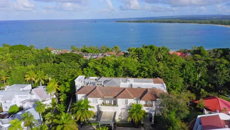 Aerial-flyover-tropical-Casa-Colonial-Beach-and-Spa-Resort-lighting-by-sun-in-front-of-Caribbean-Sea---Puerto-Plata,Dominican-Republic