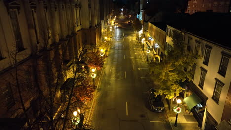 Rising-aerial-of-traffic-on-dark-one-way-urban-city-street-at-night
