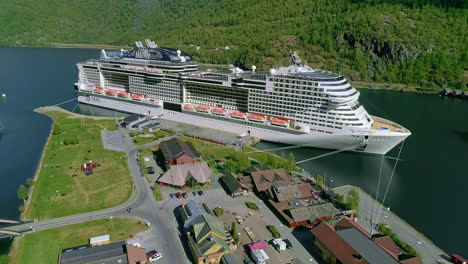Aerial-view-showing-MSC-cruise-ship-docking-at-pier-of-Flam-in-Norway-during-sunny-day