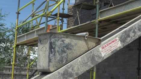 Empty-Bricklaying-Mortar-Bucket-Gets-Sent-Down-Elevator-Conveyor-Belt