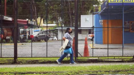 Woman-on-a-sidewalk-wearing-a-face-mask,-COVID-19-pandemic,-Panama-City,-Panama