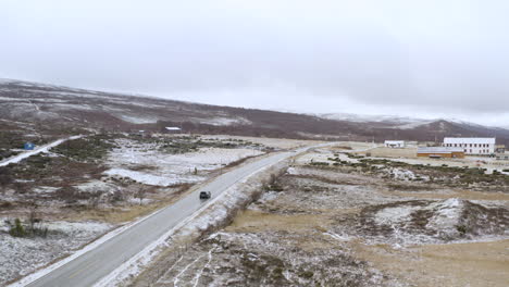 Winter-Road-Trip-Driving-In-The-Nature-Alongside-Trees-and-Snow-In-Dovre,-Norway---aerial-drone-shot