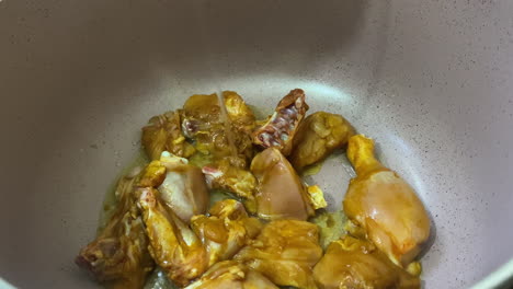 Oil-Being-Poured-In-Cooking-Pot-Over-Chicken-Pieces