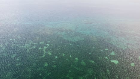 Aerial-flight-over-beautiful-coral-reef-with-rippled-turquoise-ocean-in-the-diverse-ecosystem-coral-triangle-of-Timor-Leste,-South-East-Asia