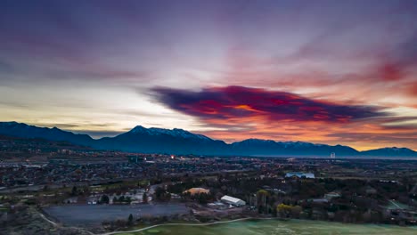 A-brilliant-sunrise-over-Utah-County-and-the-Wasatch-Front-mountain-range-with-snow-capped-mountains---aerial-hyper-lapse