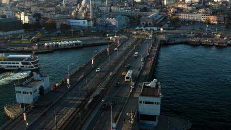 Buses-And-Cars-Driving-At-Galata-Bridge-With-Ferry-Boat-At-Golden-Horn-Near-Yeni-Cami-In-Istanbul,-Turkey