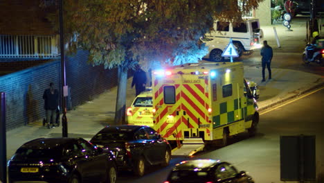 Panning-shot-of-an-ambulance-with-flashing-lights-in-North-London,-England