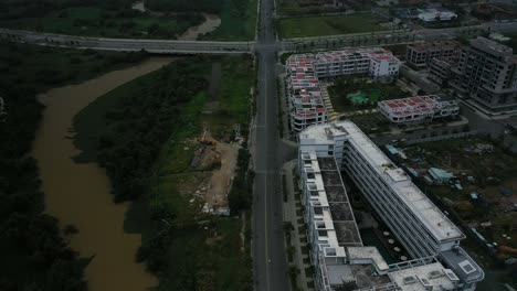 Fly-in-over-new-development,wetlands-and-roads-revealing-river-and-city-skyline-view-with-high-rise-towers-in-early-morning