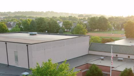 Überfliegen-Sie-Das-Dach-Der-Doe-Run-Grundschule-Und-Zeigen-Sie-Im-Hintergrund-Den-Leeren-Spielplatz-Im-Goldenen-Morgensonnenlicht