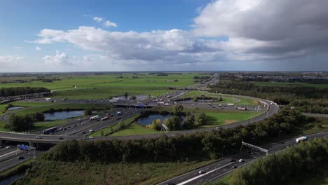 Ascending-overview-showing-Large-Oudenrijn-bypass-intersection-roundabout-near-Utrecht-with-traffic-jam-seen-from-above-with-rain-cumulus-clouds-hanging-over-it