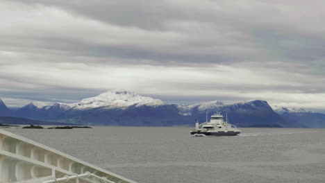 Ferry-Cruising-Towards-Molde-Port-With-Beautiful-Mountains-In-The-Background-Covered-In-Snow,-Norway