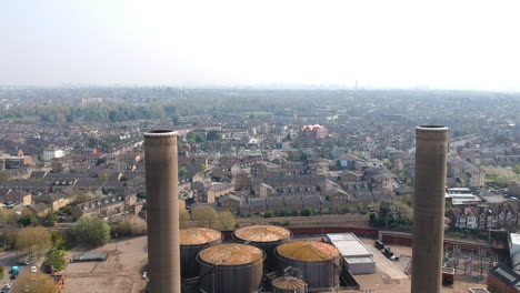 The-disused-Neasden-power-station-in-London-with-giant-chimneys-and-old-English-rooftops-in-background