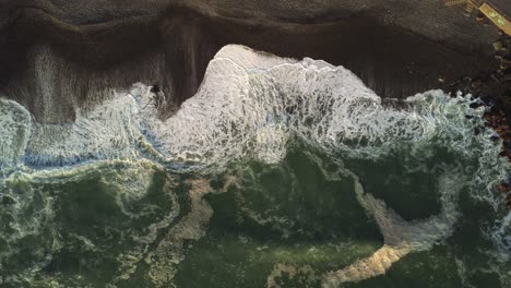 Aerial-view-above-waves-crashing-a-beach-on-the-Costa-Verde-coast-of-Miraflores,-Lima---top-down,-drone-shot