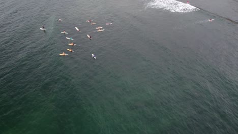 Aerial-drone-view-Shot-of-surfers-waiting-for-waves-in-the-bay-of-Sayulita,-Mexico
