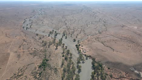 Aerial-view-slowly-tilt-up-from-Brachina-Gorge-to-outback-horizon,-Flinders-Ranges