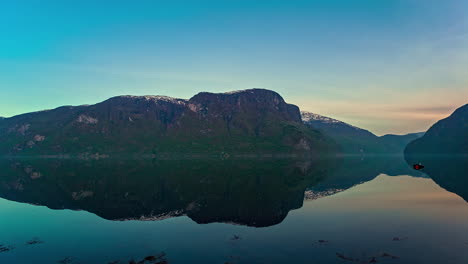 Zeitrafferaufnahme-Eines-Kreuzfahrtschiffes-Im-Fjord-Bei-Wunderschönem-Sonnenaufgang-Mit-Wasserspiegelung-Der-Berge