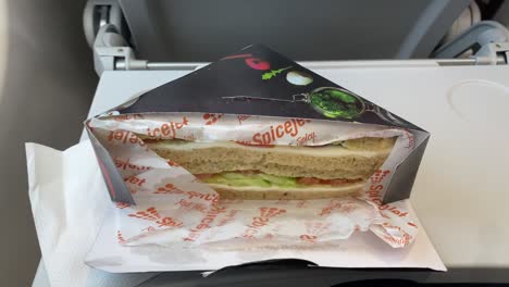 Inside-spice-jet-with-refreshments-like-sandwich,-water-cup,-tissue-paper-and-Paper-Boat's-lychee-juice