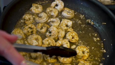 Sauteing-shrimp-in-butter-and-herbs-in-a-frying-pan-on-the-stove---shrimp-and-grits-meal