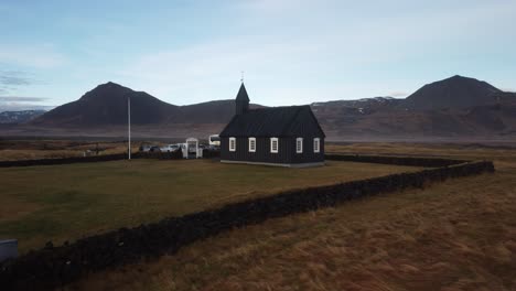 Tiny-wooden-church-in-a-scenic-natural-area-with-a-lava-field