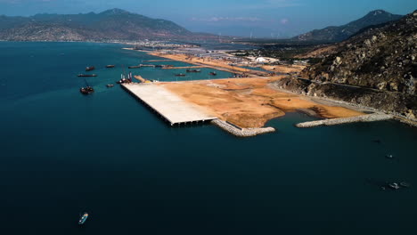 Building-massive-harbor-of-Ca-Na-in-Vietnam,-aerial-drone-view-over-blue-ocean