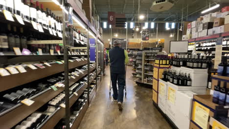 Shopper-walks-through-aisle-at-Total-Wine-and-More,-looking-for-bargain-alcohol-to-buy