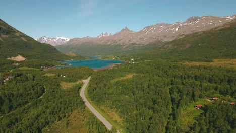 Grüne-Landschaft-Auf-Dem-Land-Mit-Piggtindens-Gipfel-Im-Hintergrund-In-Der-Nähe-Von-Tromsø,-Nordnorwegen