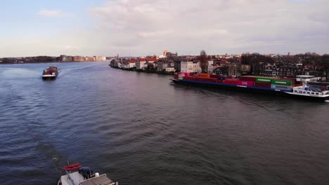 Luftbild-Einer-Fliegenden-Drohne,-Frachtcontainerschiff-Sensation,-Die-Entlang-Der-Oude-Maas-An-Dordrecht-Vorbeisegelt