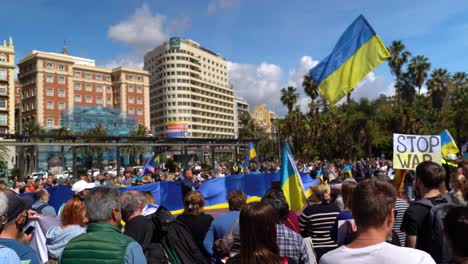 Wide-open-view-of-speaker-at-rally-against-war-in-Ukraine-with-many-flags
