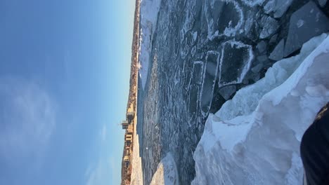 Vertical-video,-pancake-ice-formations-on-Duluth's-Lake-Superior-shore,-winter