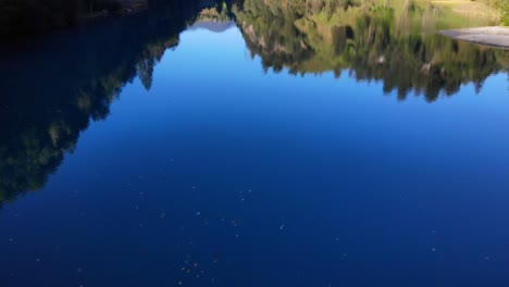 Beautiful-Reflection-Of-Lush-Vegetation-On-Lake-Klammsee-In-Austria---aerial-drone-shot