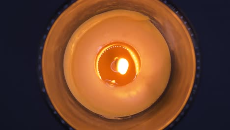 Overhead-Shot-Of-Burning-Scented-Candle-Rotating-Against-Black-Background