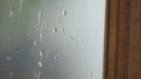 Zeitlupe-Von-Wasser-Auf-Einem-Fenster,-Während-Es-Im-Hintergrund-Regnet