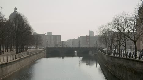 Die-Spree-Schwimmt-Durch-Eine-Brücke-In-Berlin-Mit-Der-Stadt-Berlin-Im-Hintergrund