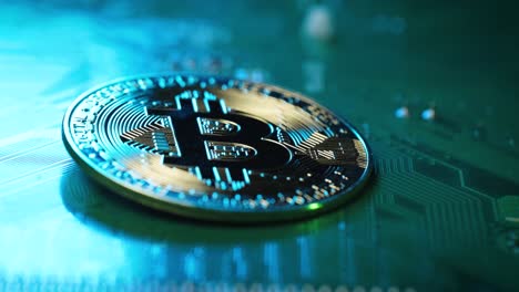 Dolly-motion-towards-Golden-Bitcoin-on-integrated-circuit-board,-Mining-bitcoin-Concept