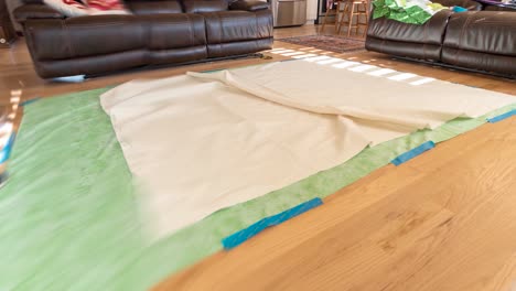 Laying-out-the-bottom,-backing-and-quilt-top-on-the-floor-and-then-gluing-or-basting-them-together-before-quilting-on-a-pattern---time-lapse
