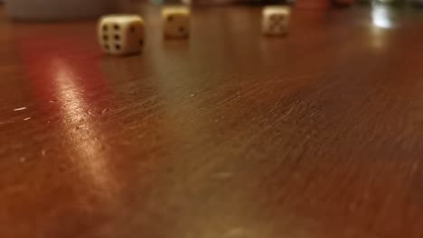 Numerous-dice-rolling-across-a-wooden-table-top