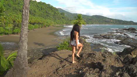 Woman-walking-and-climbing-over-rocks-on-coast-of-Costa-Rica,-South-America