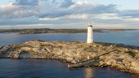 Coastal-Lighthouse-On-The-Island-of-Lille-Torungen-In-Arendal,-Agder-County,-Norway---aerial-drone-shot
