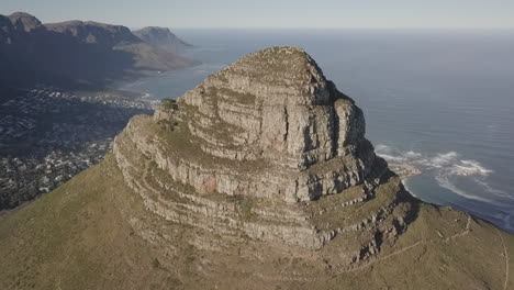 Aerial-retreats-from-Lion's-Head-peak-with-calm-Indian-Ocean-beyond