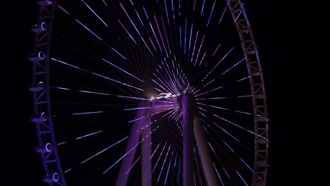 Close-up-of-Ain-Dubai-light-show-at-night,-Observation-wheel-in-blue-water-island