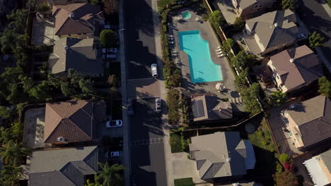 Drone-flying-slowly-over-residential-neighborhood-with-pool-in-the-suburbs